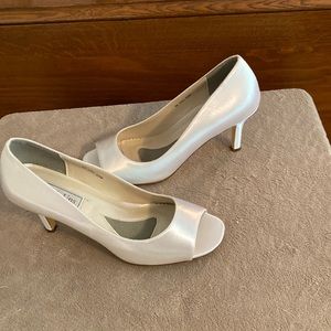 White satin peep toe pump in a size 8M. The shoe has a 2 and 3/4 inc heel New